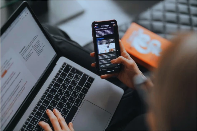 Person looking and laptop screen and mobile