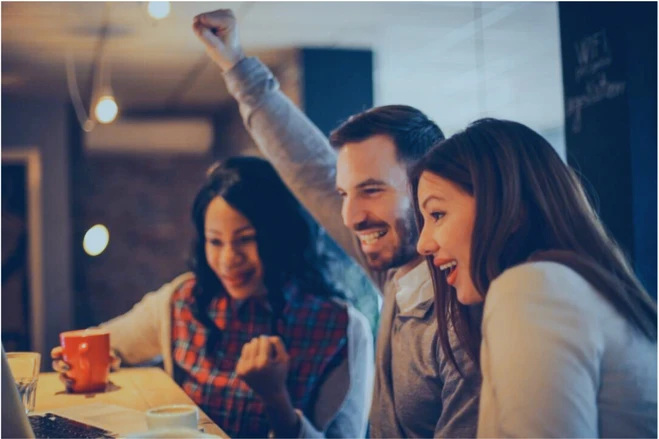 Celebrating people looking at a computer screen